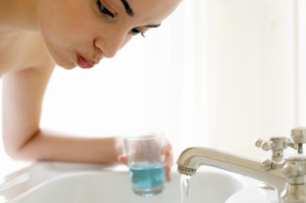 Woman using mouthwash Woman using mouthwash