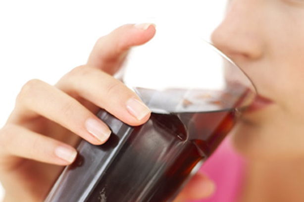 A woman drinking a glass of cola