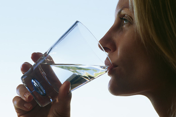A woman drinking a glass of water A woman drinking a glass of water