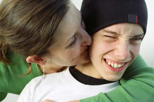Love teenagers kiss hug mother son