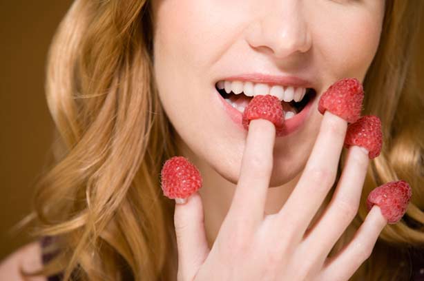A woman eating raspberries