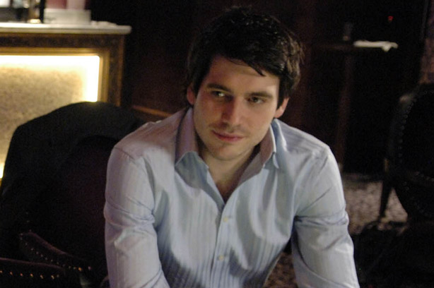 Rob James-Collier who plays Liam Connor in Coronation Street sits on a chair looking thoughtful_ITV images