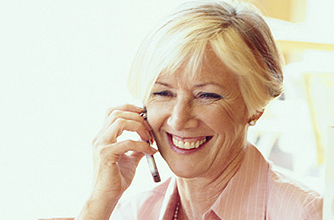 A woman smiling and talking while on a mobile phone