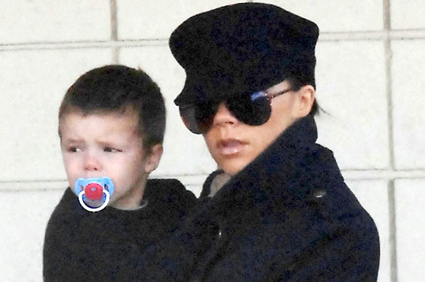 Victoria Beckham carries her youngest son Cruz with a dummy in his mouth_rex