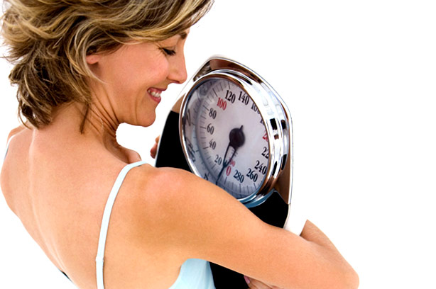 Happy woman holding scales