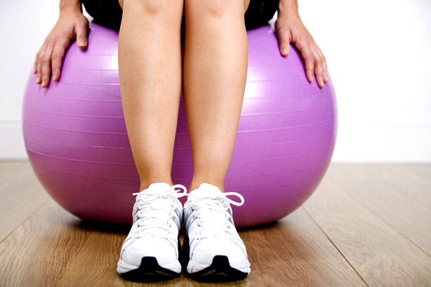 Woman sitting on Pilates ball