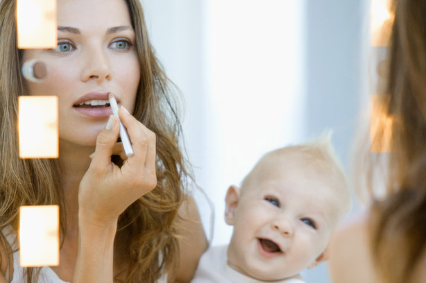 Woman looking into a mirror holding her baby