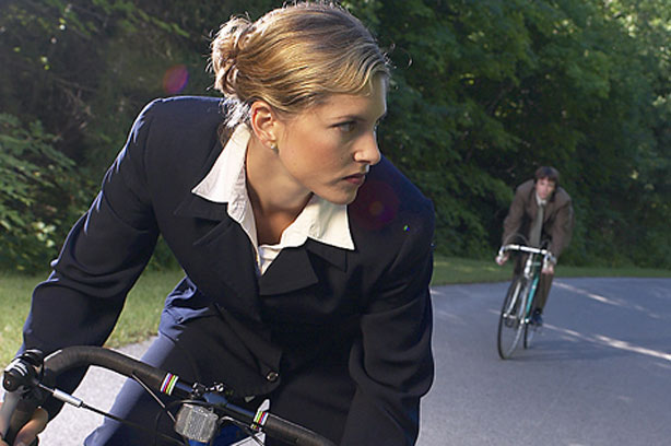 woman cycling with a man behind her on a bicycle