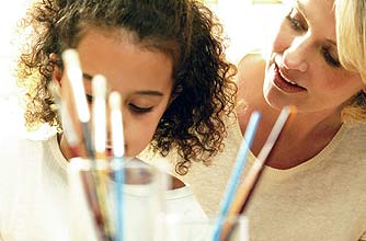 A girl painting with her mum