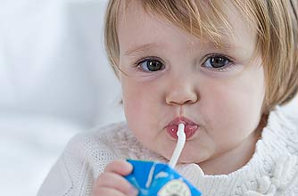 A girl using a straw to drink juice