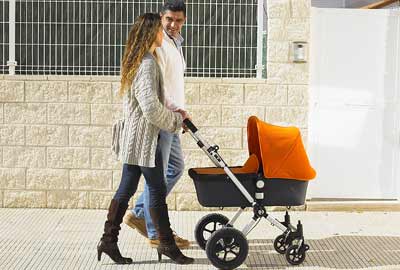 Parents pushing baby in a pram Parents pushing baby in a pram