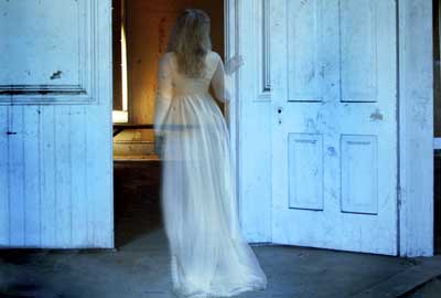 Ghostly woman walking through door Ghostly woman walking through door