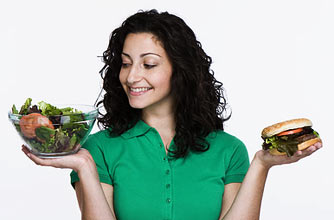Woman choosing between salad and burger_Photolibrary
