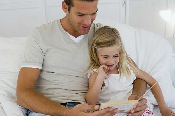 A dad and his daughter reading together