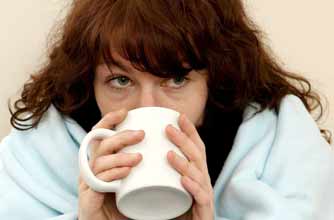Woman with common cold drinking a hot drink_REX