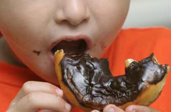 Boy eating chocolate doughnut_Istock