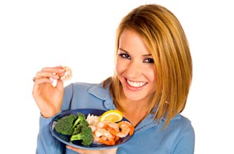 Woman eating prawns and broccoli Woman eating prawns and broccoli