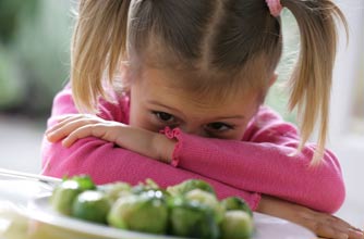 girl unhappy at plate of Brussles sprouts girl unhappy at plate of Brussles sprouts
