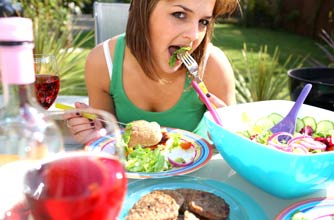Woman eating salad at a barbecue