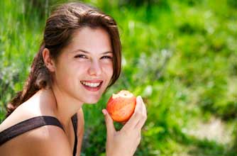 woman eating apple in sun
