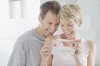 An excited couple look at a pregnancy test