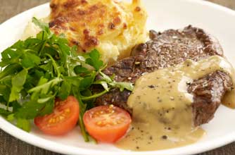 Steak with brandy and peppercorn sauce