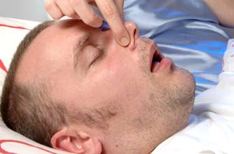 Woman holding her partner's nose to stop him from snoring