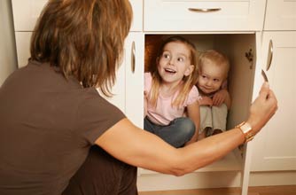 Two girls playing hide and seek with their mum