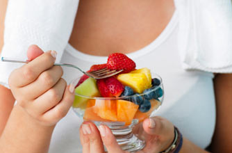 woman eating fruit after exercising woman eating fruit after exercising