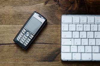 mobile phone and a keyboard on a desk mobile phone and a keyboard on a desk