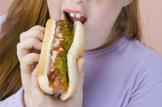 Obese girl eating a hotdog