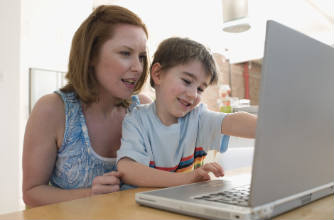 Mum helping her son on the computer