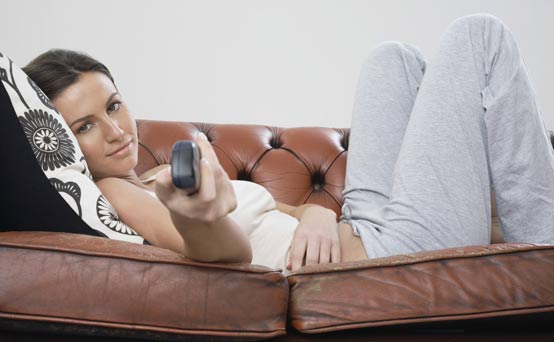 Woman changing the TV channel Woman changing the TV channel