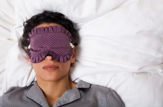 Woman in bed wearing sleep mask