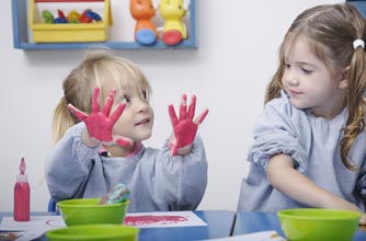 Girls finger painting at nursery