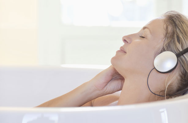 Woman listening to relaxing music in bath Woman listening to relaxing music in bath