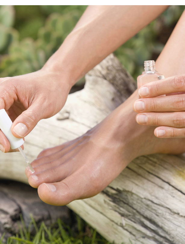 Woman painting toe nails Woman painting toe nails