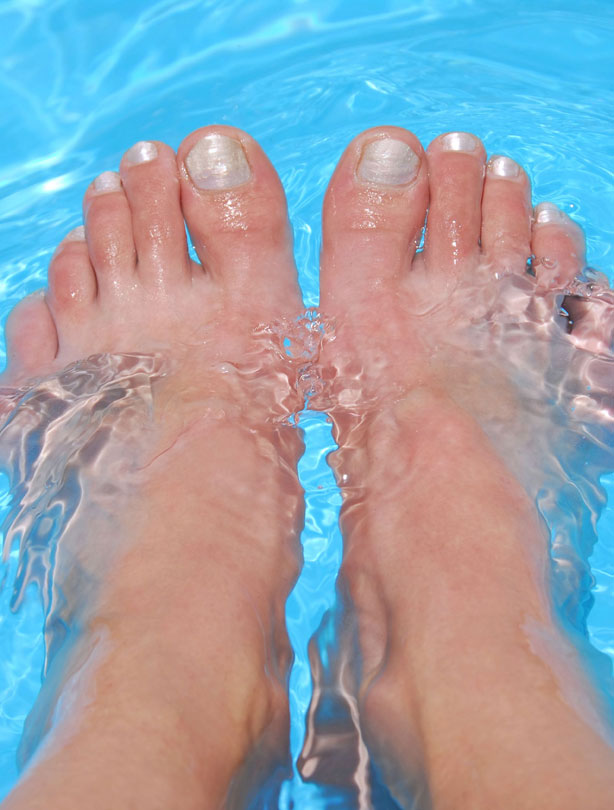 woman with feet in pool woman with feet in pool