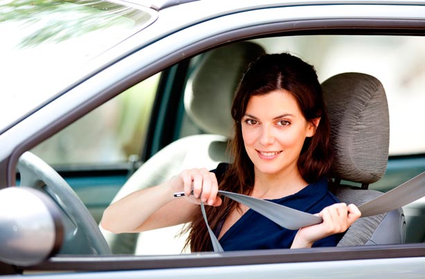 Woman putting on seatbelt Woman putting on seatbelt