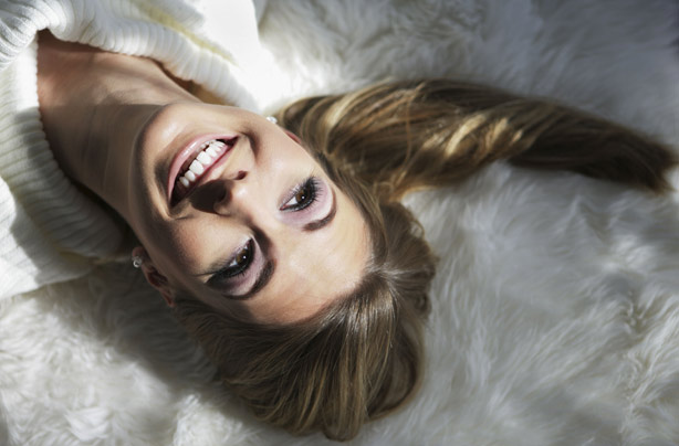 Smiling happy single woman on bed
