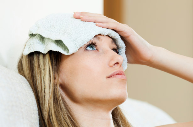 Woman with a wet flannel on her head Woman with a wet flannel on her head
