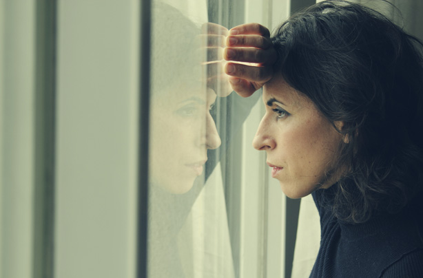 Woman looking out of a window, stress