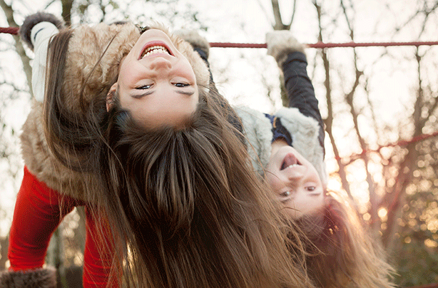 Girls swinging on playground, child development stages